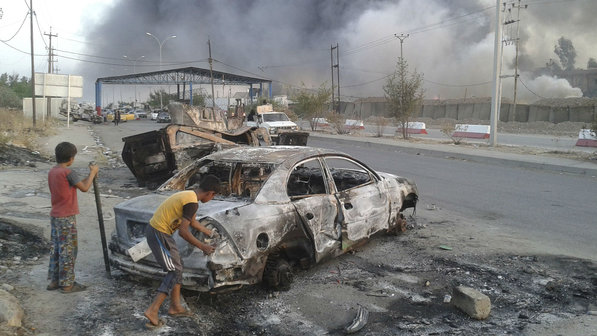 Criancas-observam-carro-destruido-apos-ofensiva-terrorista-em-Mosul-no-Iraque-size-598